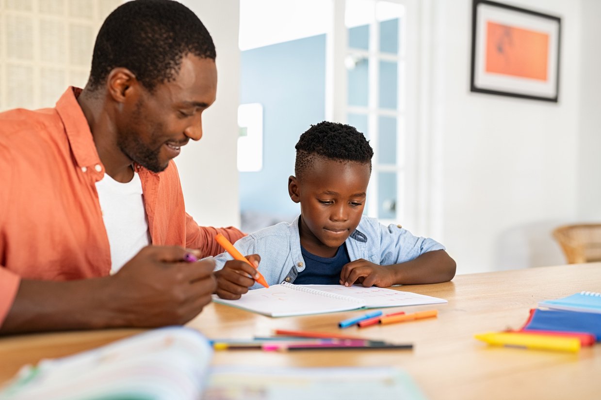 Mature Black Father Helping Son with Homework