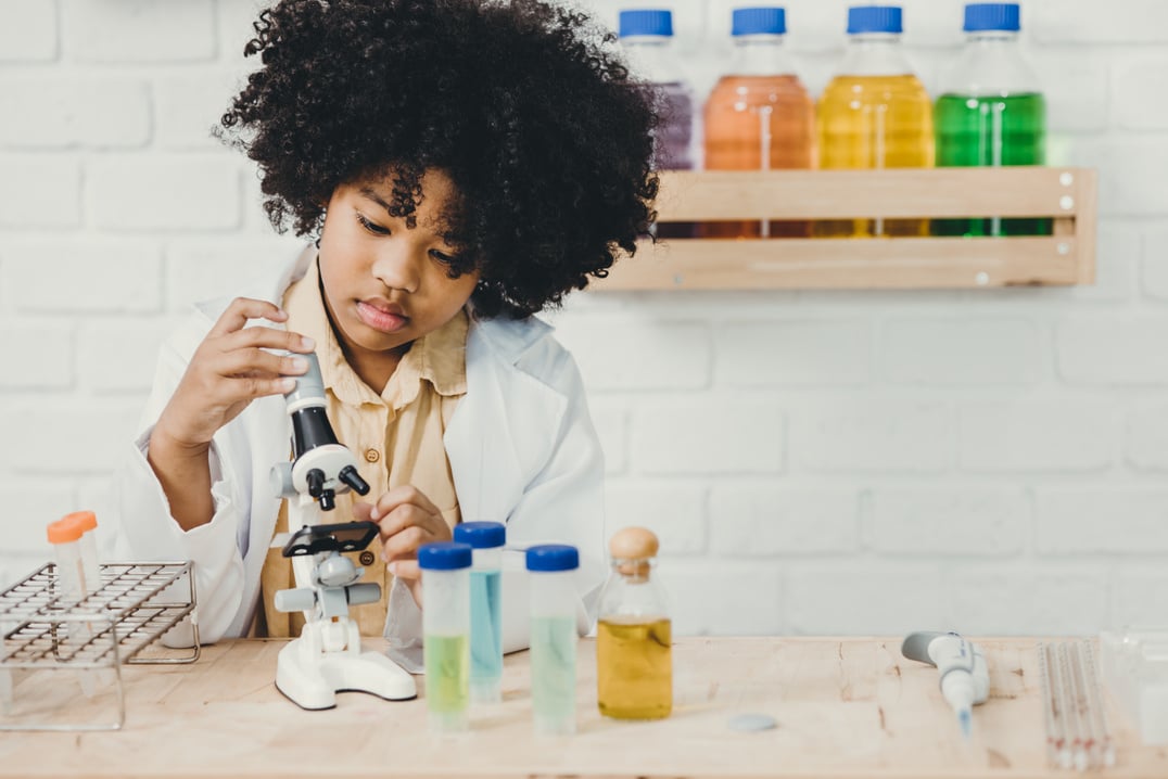 Scientist Kid play in school science lab kit. Learning education black child girl smiling.